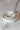 PLATS DE SERVICE DROITS - Set of elegant white fine china dinner plates with gold trim and ornate design.