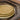 Plateaux Ronds Empreinte Kaki Gold ceramic plate with golden embossed design and earthy brown tone.