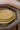 Plateaux Ronds Empreinte Kaki Gold ceramic plate with golden embossed design and earthy brown tone.